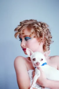 woman holds a white chihuahua